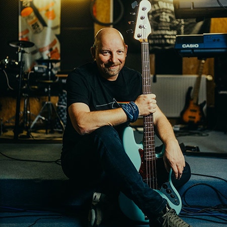 Musikfan Chris Lilieweiß sitzend mit E-Gitarre