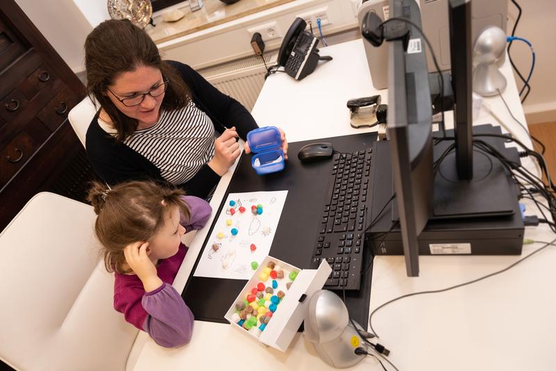 Online Sprachübung vor dem PC Bildschirm mit kreativen Spielmaterialien